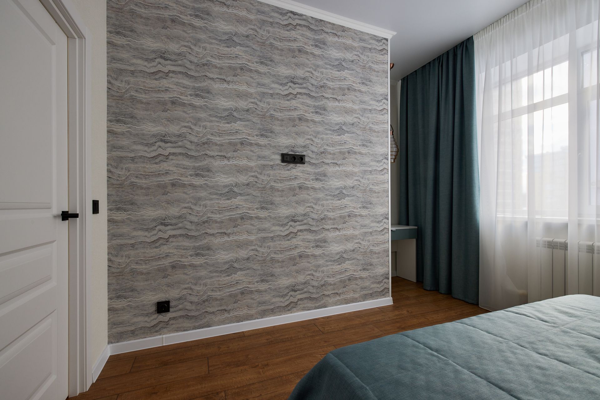 A bedroom with a brick wall and a bed.