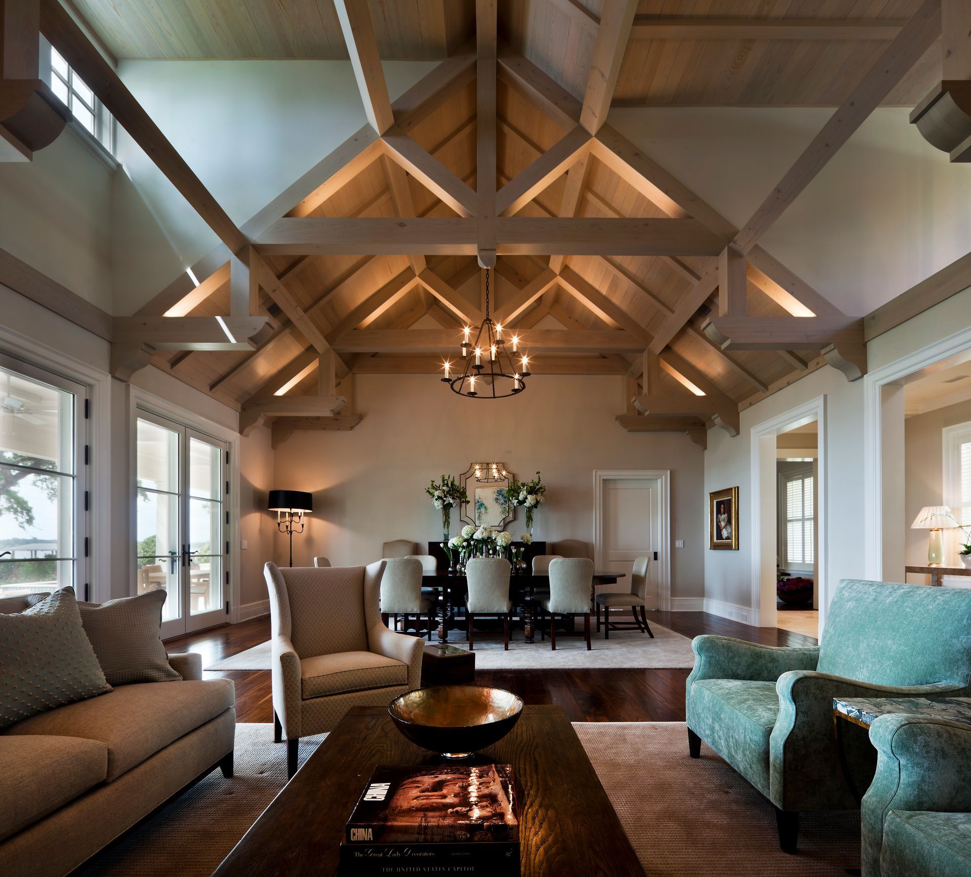 Living room with high wood beam ceiling, dining table, and comfortable seating.