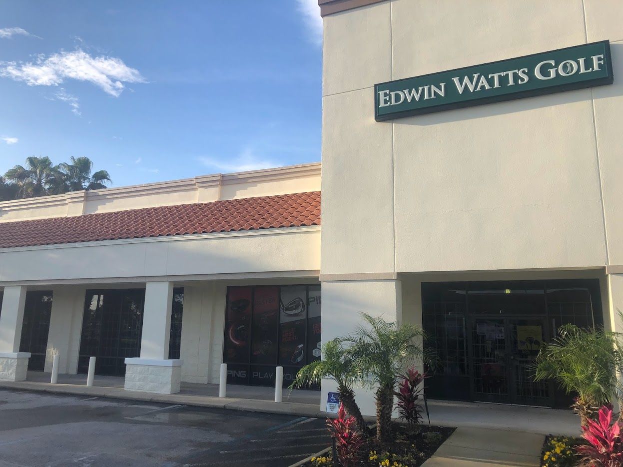 Exterior of Edwin Watts Golf store, light-colored building with a green sign.