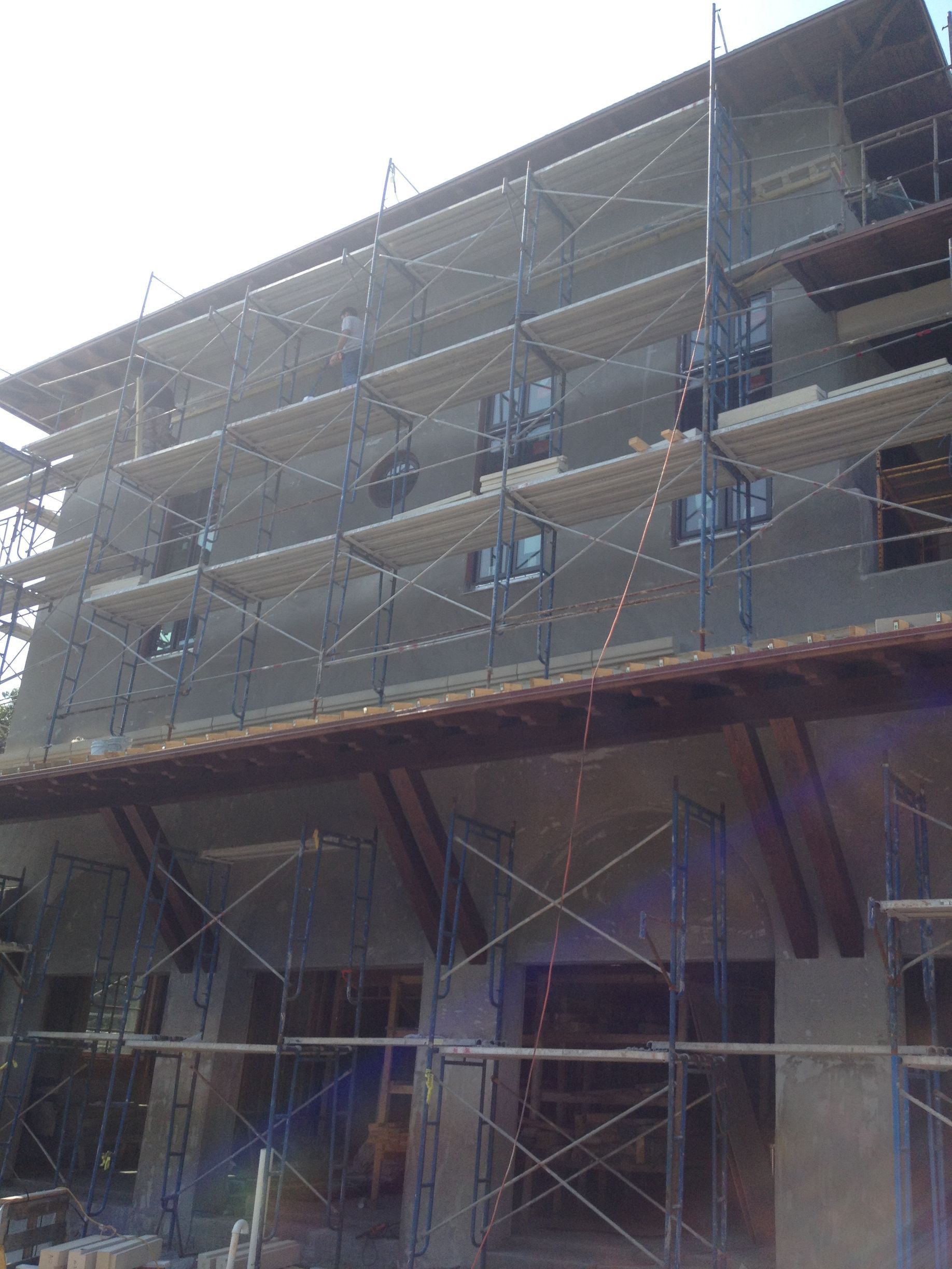 Building under construction, with scaffolding around the exterior and windows.