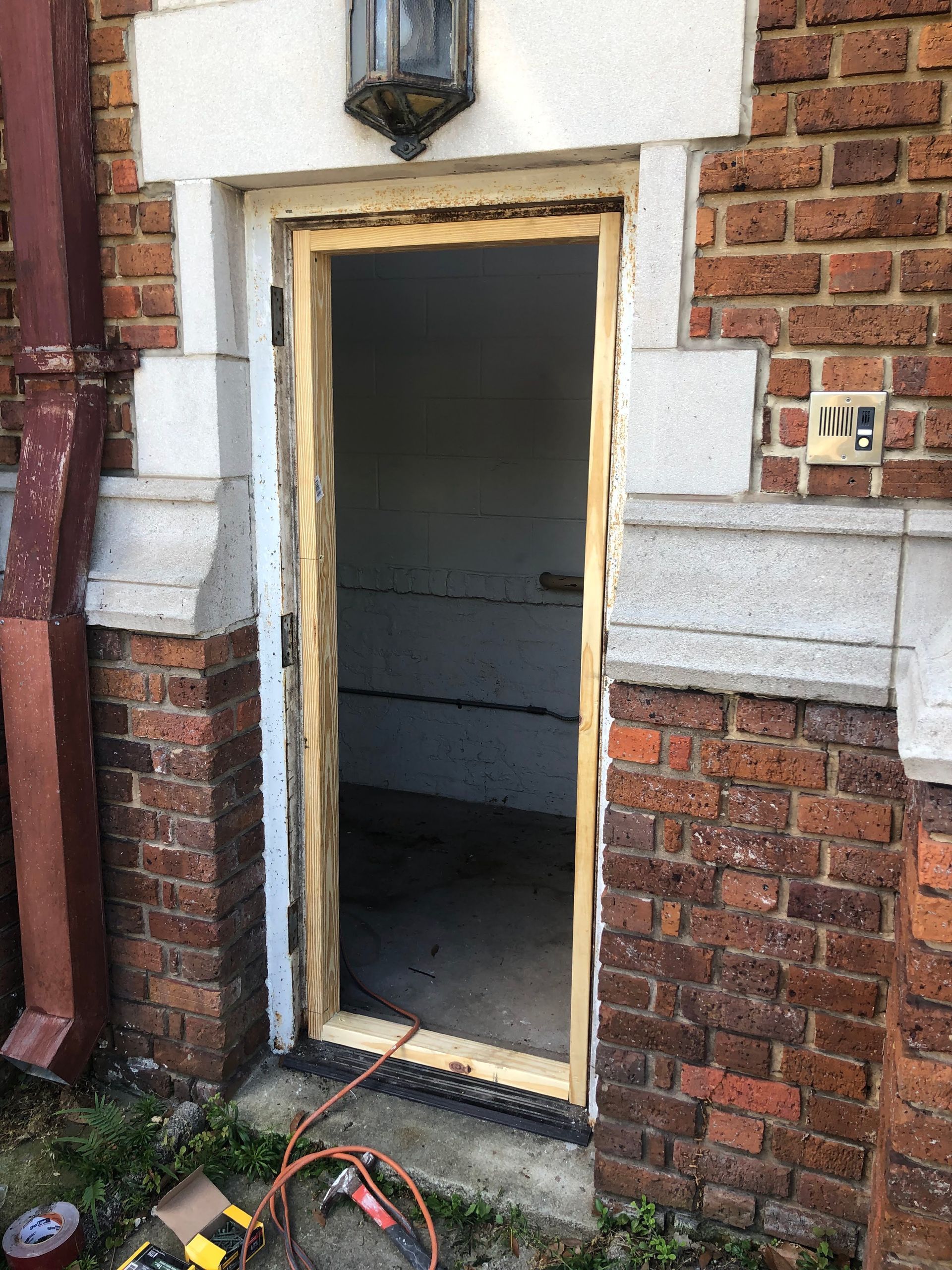 Exterior doorway with wooden frame, set in brick building.