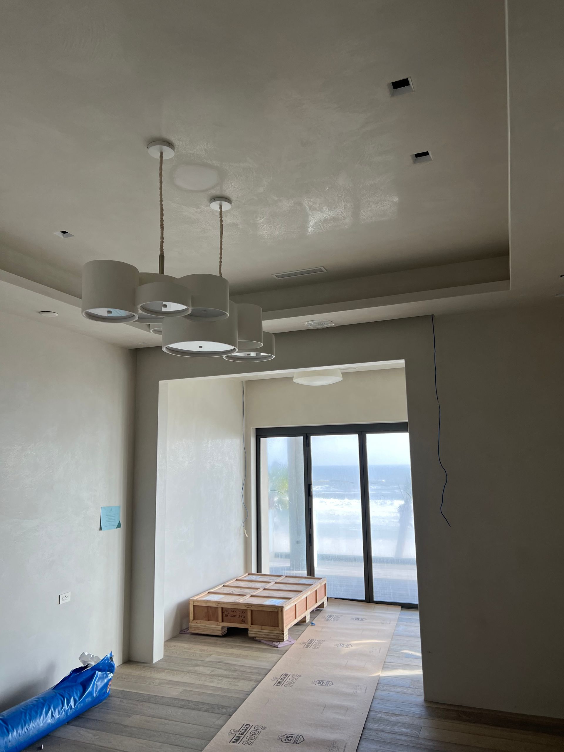 Interior with unfinished walls, pendant lights, doorway to a glass door, and a wooden pallet.