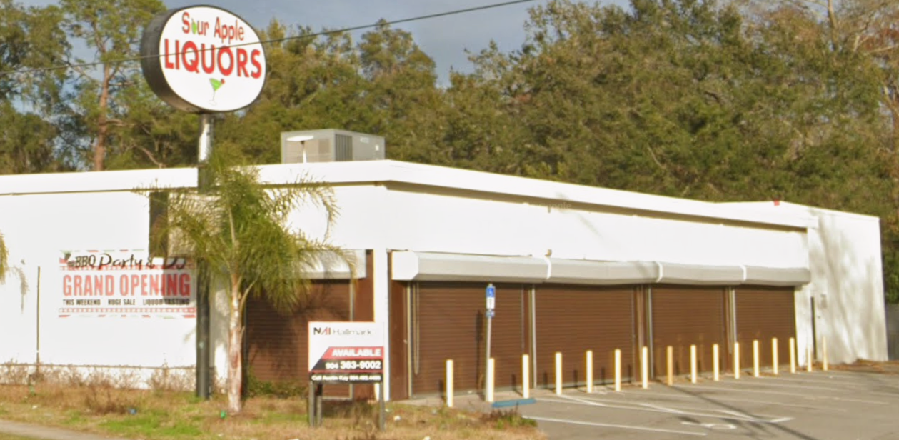 Exterior view of a liquor store with a sign reading 