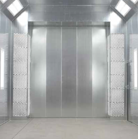Empty, metallic-walled spray paint booth with filtered air panels, bright lights, and a solid, gray floor.