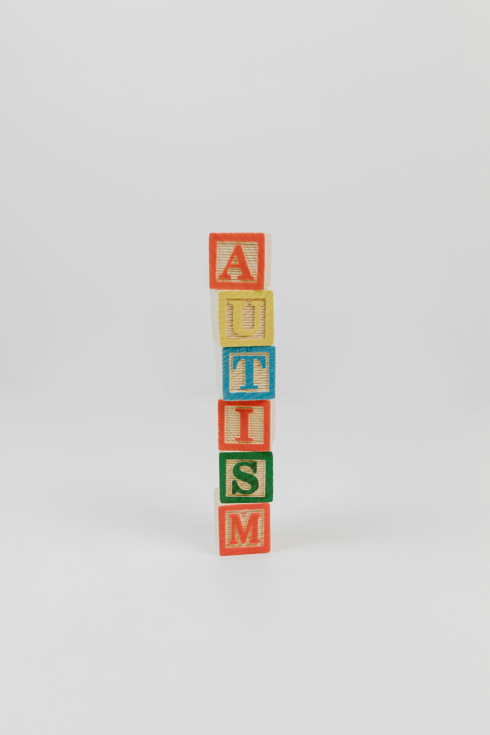 A vertical stack of six colorful alphabet blocks spelling out the word 