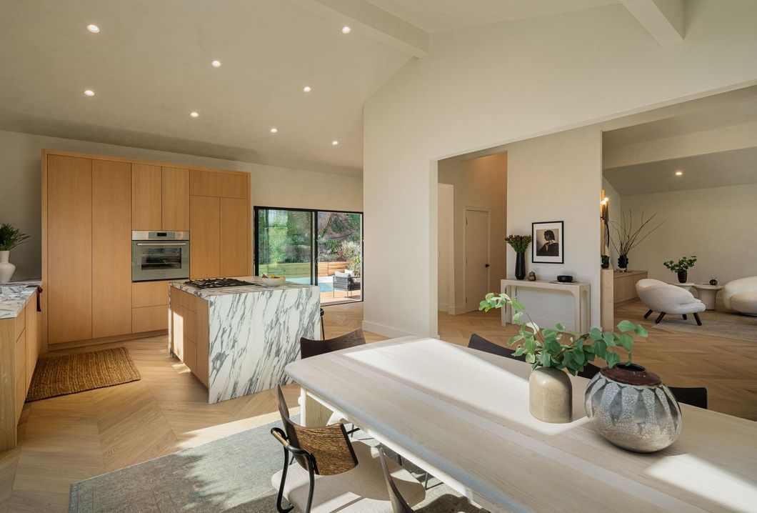 A kitchen and dining room in a house with a table and chairs.