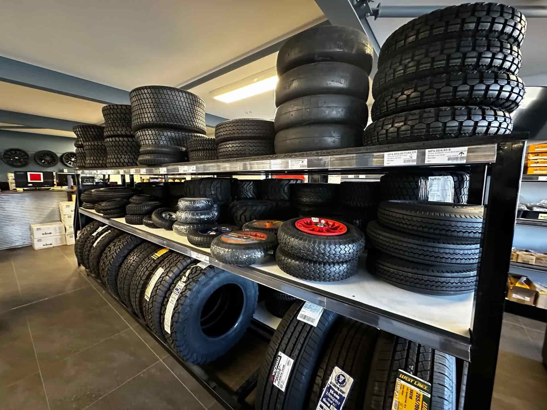 A Bunch Of Tires Are Stacked On Shelves In A Store — Smitty's Tyres & More In Taminda, NSW