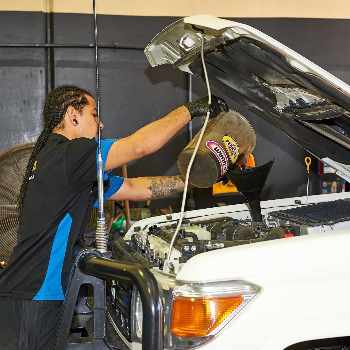 A Man Is Working on The Engine of A White Truck — Smitty's Tyres & More In Manilla, NSW