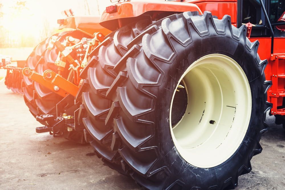 A Row Of Tractor Tires Are Sitting Next To Each Other In A Parking Lot — Smitty's Tyres & More In Taminda, NSW