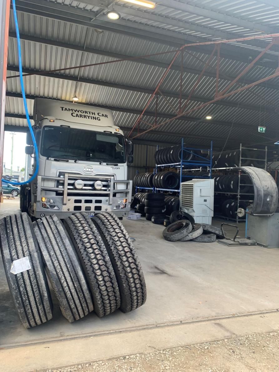 A Truck Is Parked in A Garage Next to A Pile of Tires — Smitty's Tyres & More In Uralla, NSW