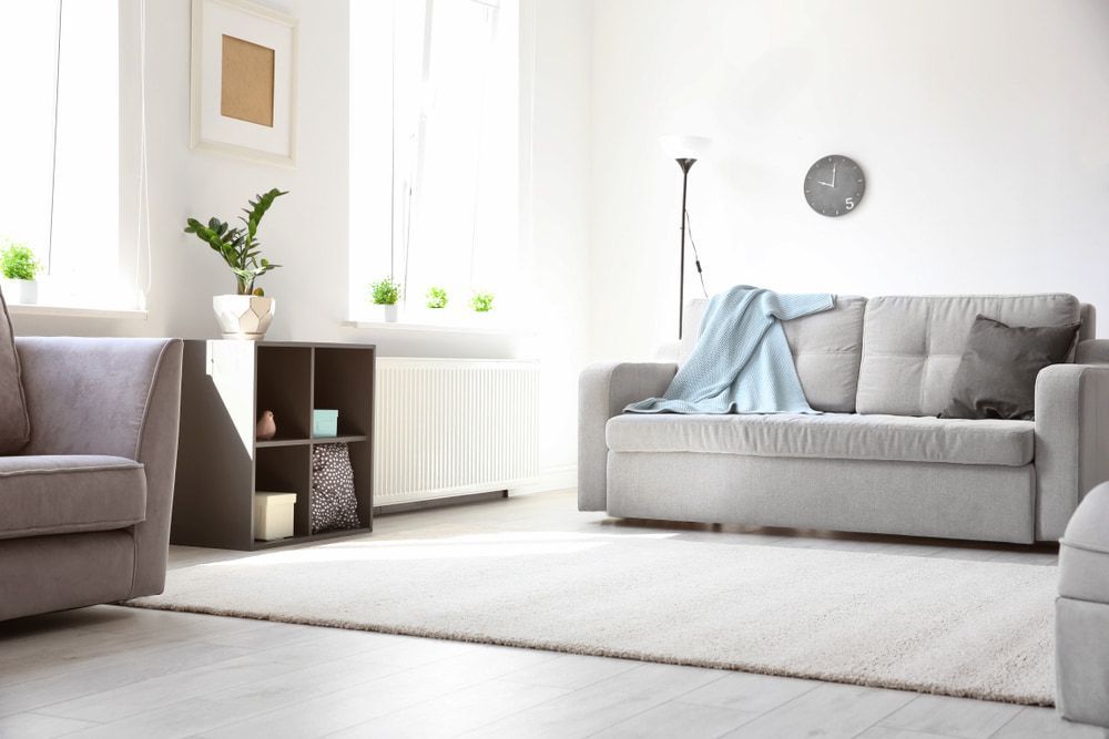 A Living Room With A Couch, Chair, And Rug — Ozwide Flooring in Ciccone, NT