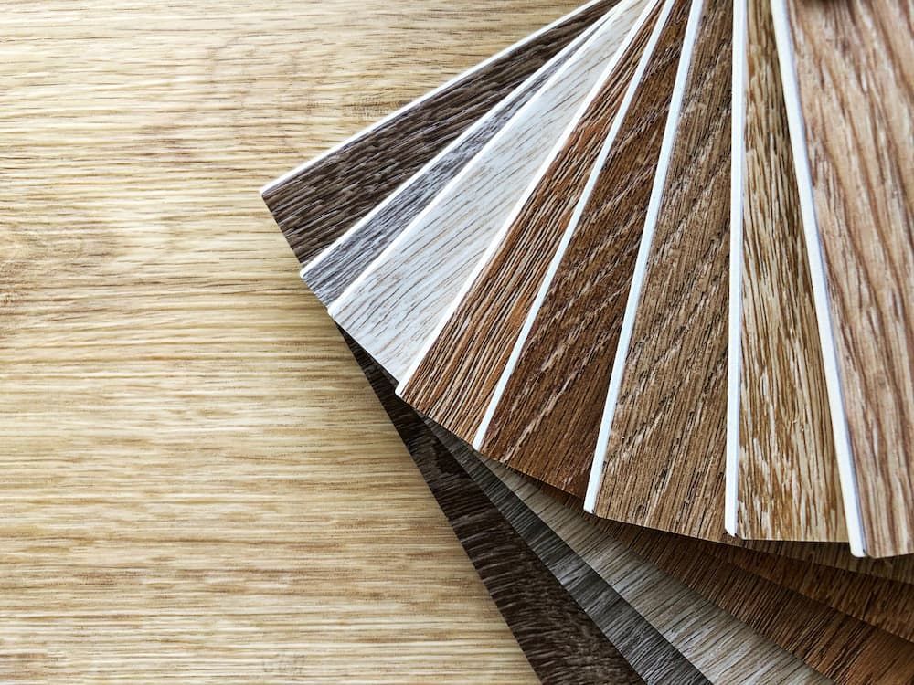 A Fan Of Different Types Of Wood Samples On A Wooden Table — Ozwide Flooring in Ciccone, NT