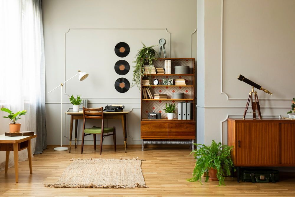 A Living Room With A Desk, Chair, Bookshelf, Plants And Flooring — Ozwide Flooring in Ciccone, NT