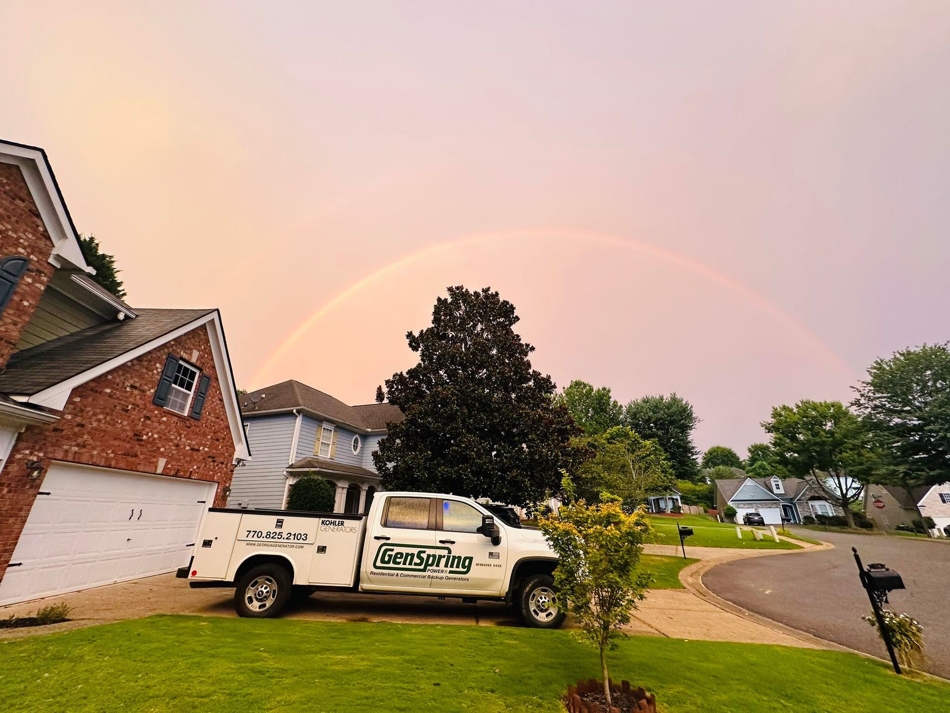 A rainbow and sunset over a north Georgia neighborhood with a GenSpring Power truck parked. 