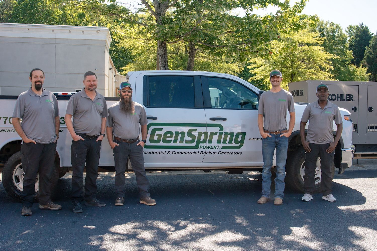Five men standing beside a GenSpring service van in a sunny parking lot