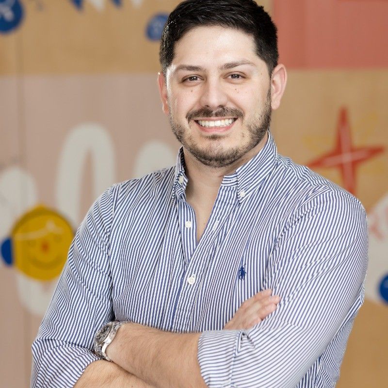 Um homem com barba e óculos está sorrindo para a câmera.