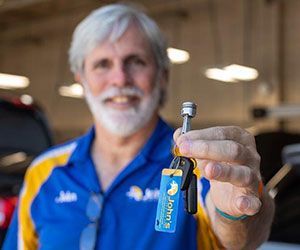 Man in blue shirt, holding keys with 
