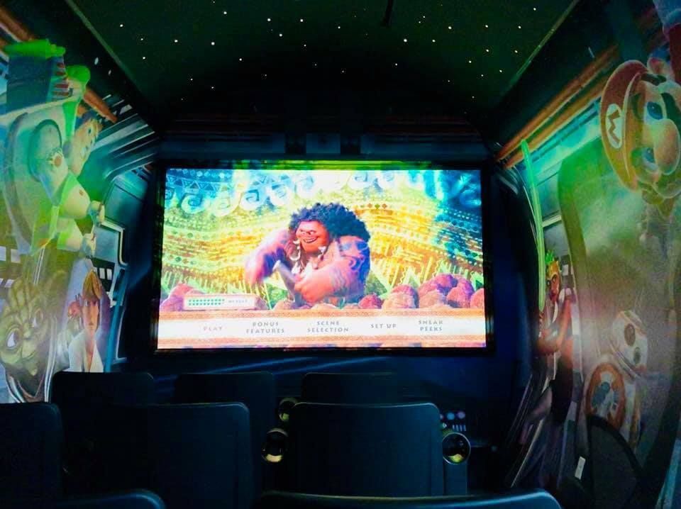 A dark movie theater shows a scene from