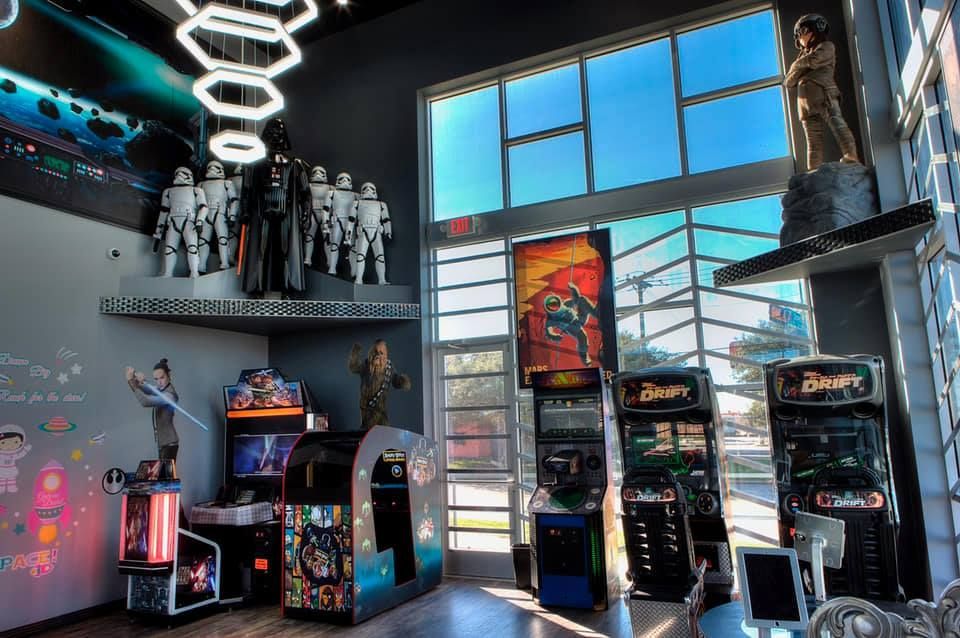 Arcade with Star Wars figures, games, posters, and large windows.