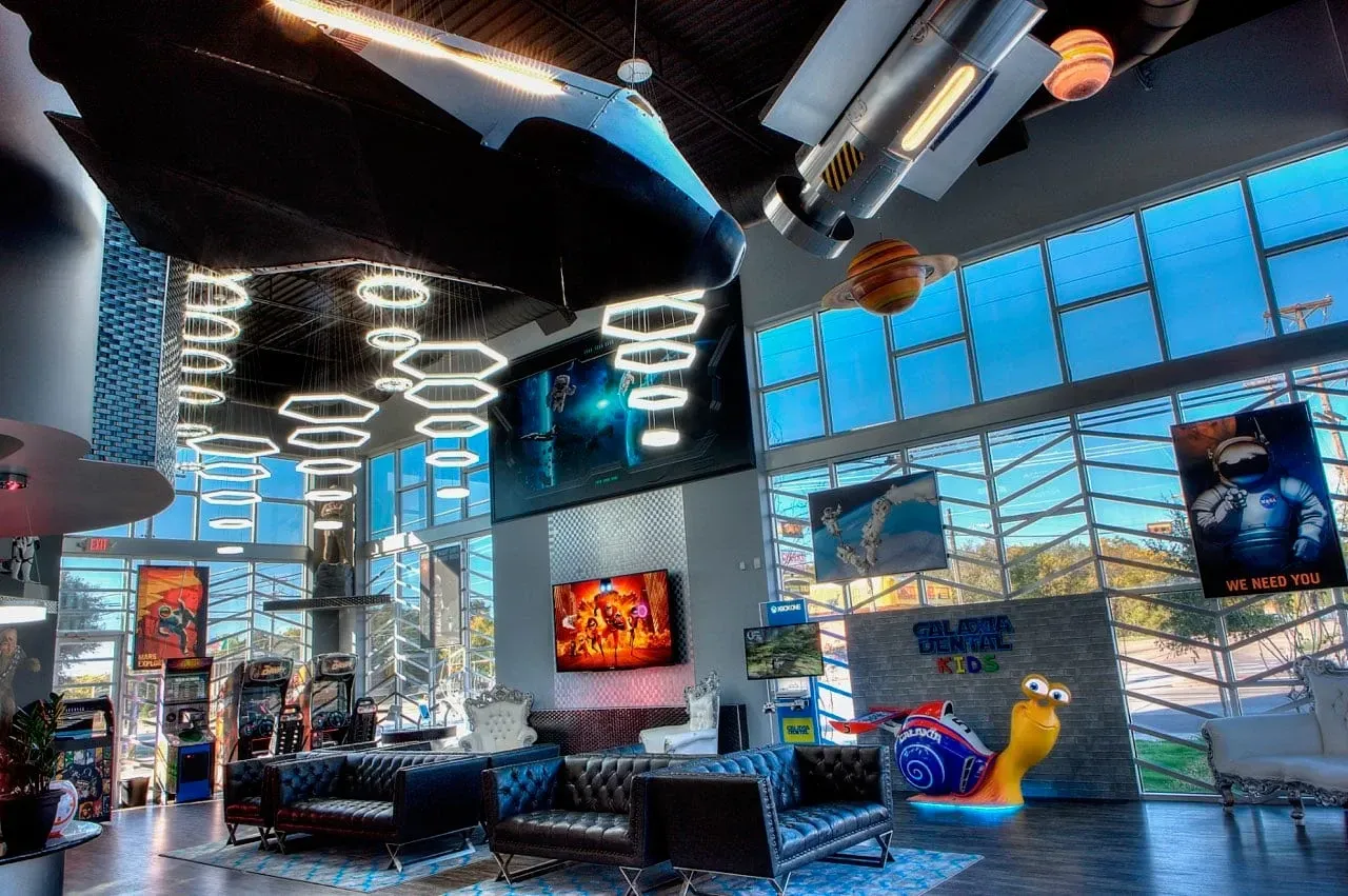 Game room with space-themed decor, including a shuttle and arcade games.