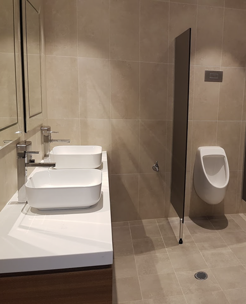 a bathroom with two sinks and a urinal .