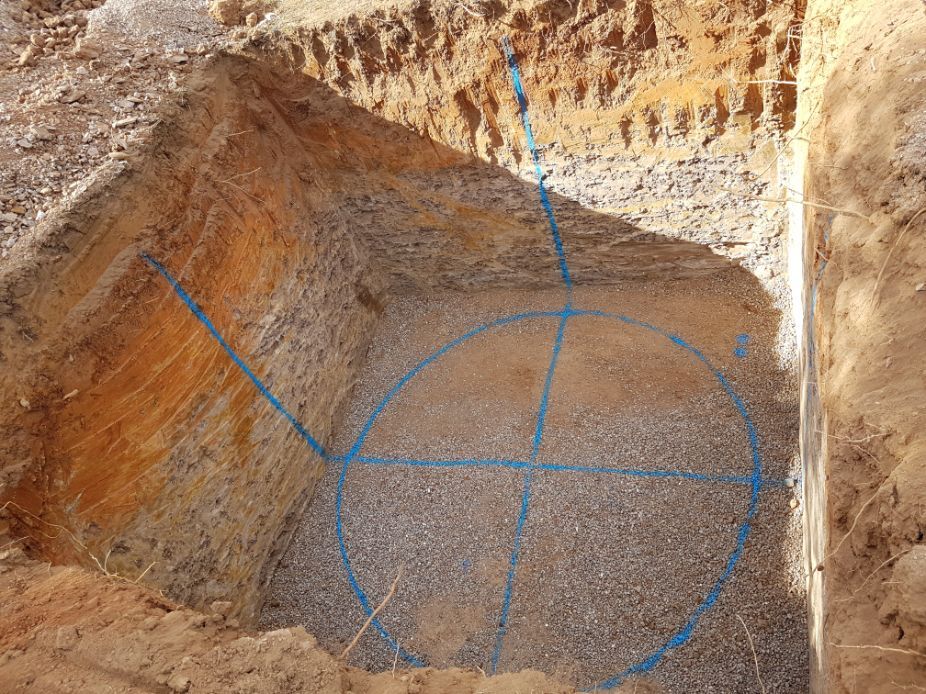 a hole in the ground with a blue circle drawn on it .