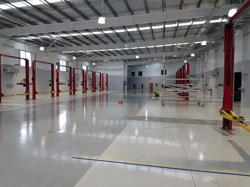 a large empty warehouse with a lot of lifts in it .