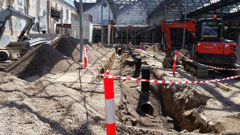 a construction site with a lot of machinery and pipes in the dirt .