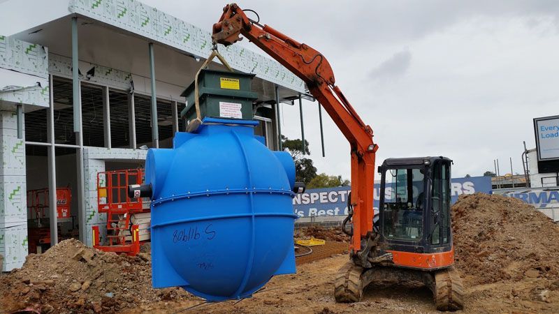 a large blue tank is being lifted by a crane .