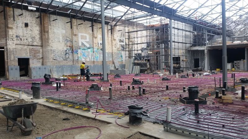 a large building under construction with a purple floor and scaffolding .