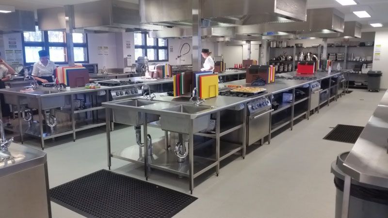a large kitchen with a lot of stainless steel appliances and sinks .