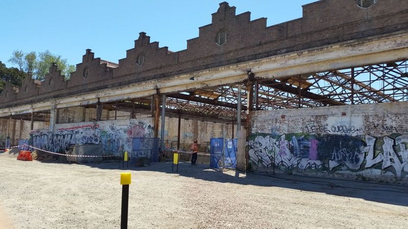 a building with graffiti on the side of it and a yellow pole in front of it .