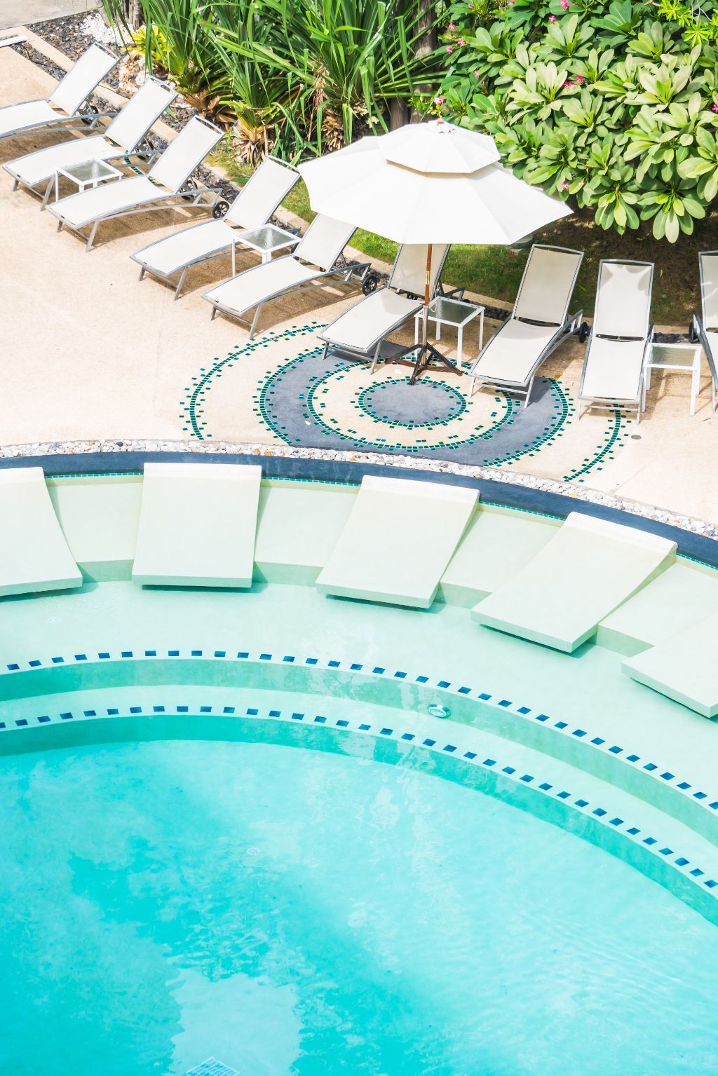 an aerial view of a swimming pool surrounded by chairs and umbrellas .