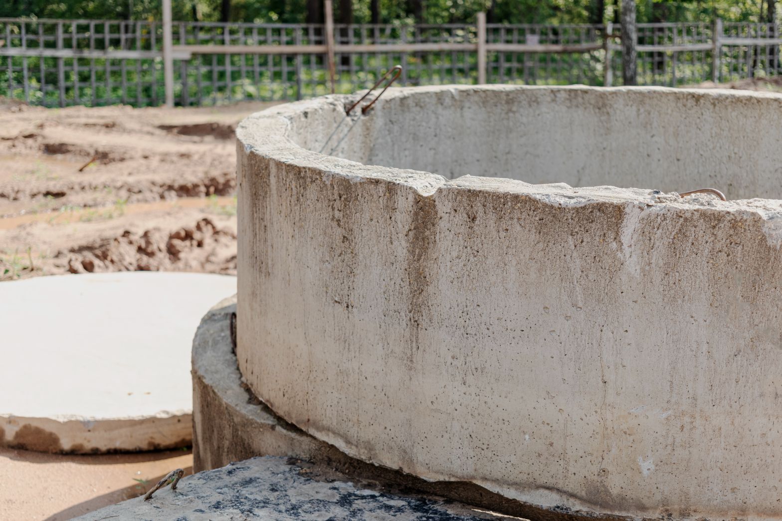 a concrete ring is sitting on top of a concrete slab on a construction site .