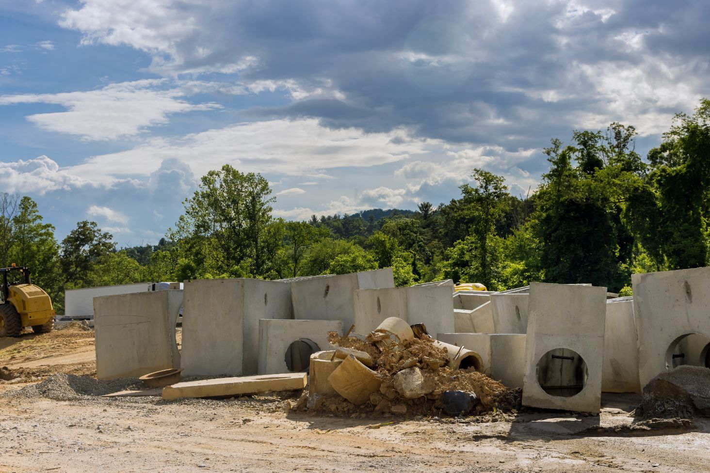 a construction site with a lot of concrete blocks and a bulldozer in the background .