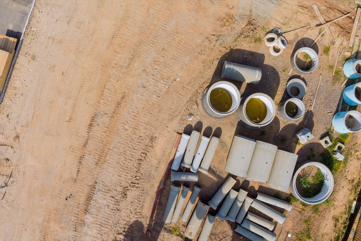 an aerial view of a pile of pipes in a dirt field .