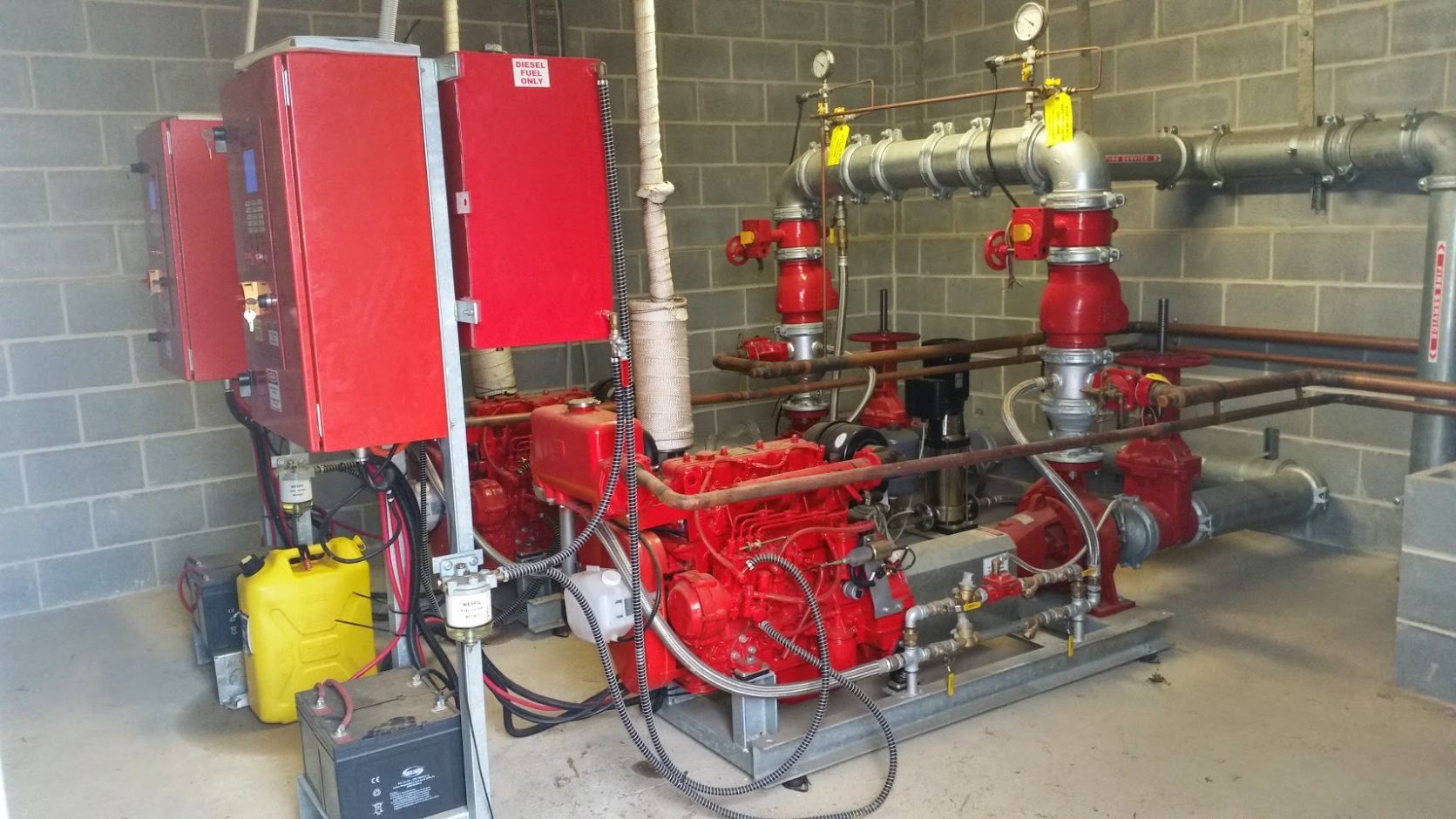 a room filled with lots of pipes and a red box .