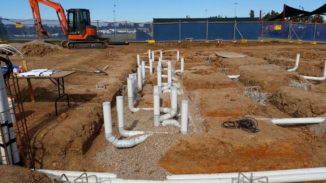 a construction site with pipes and a bulldozer in the background .