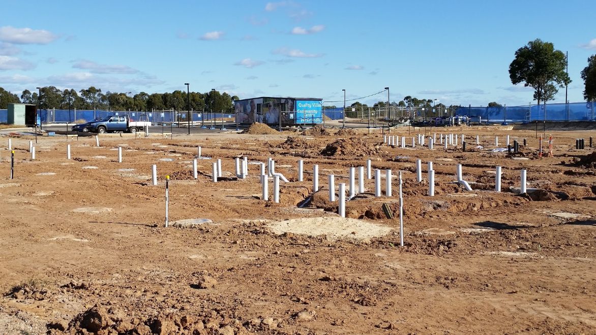 a construction site with a lot of pipes in the dirt .