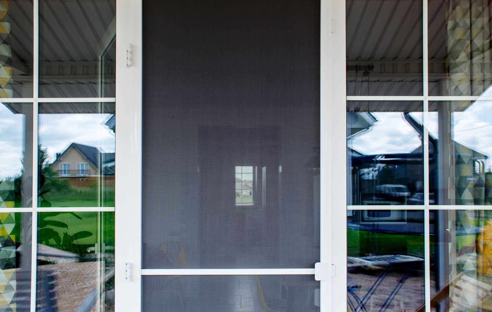 A residential security door between two glass windows.