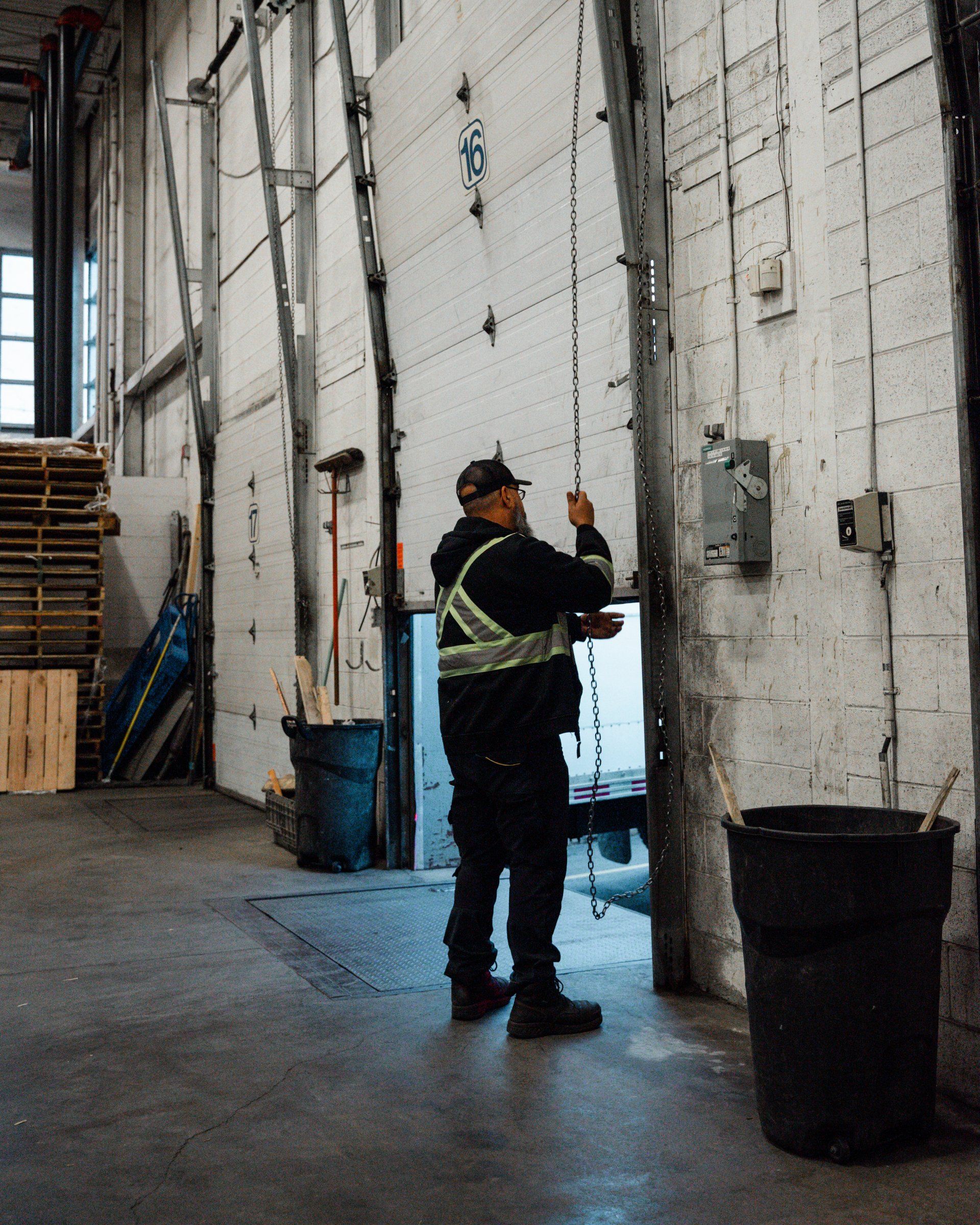 Un homme ouvre une porte de garage dans un entrepôt