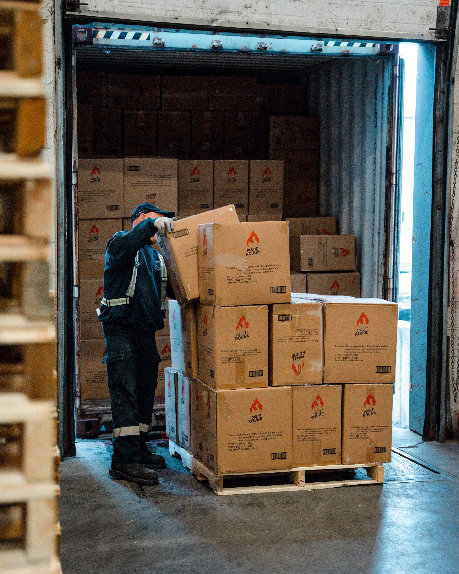 Un homme charge des cartons dans un camion dans un entrepôt.