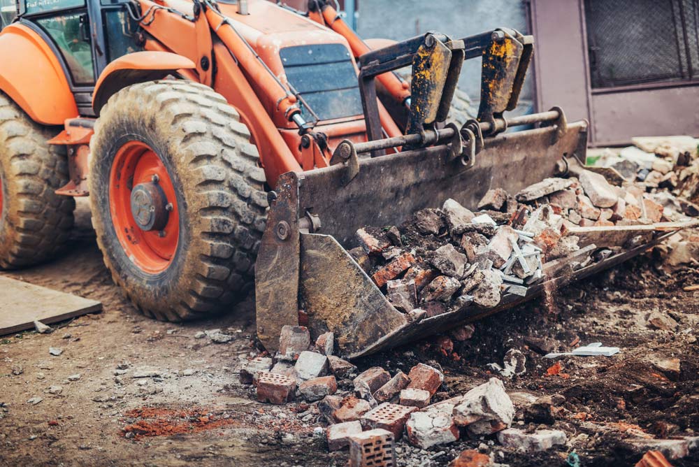 Excavator Working On A Construction Site With Debris
