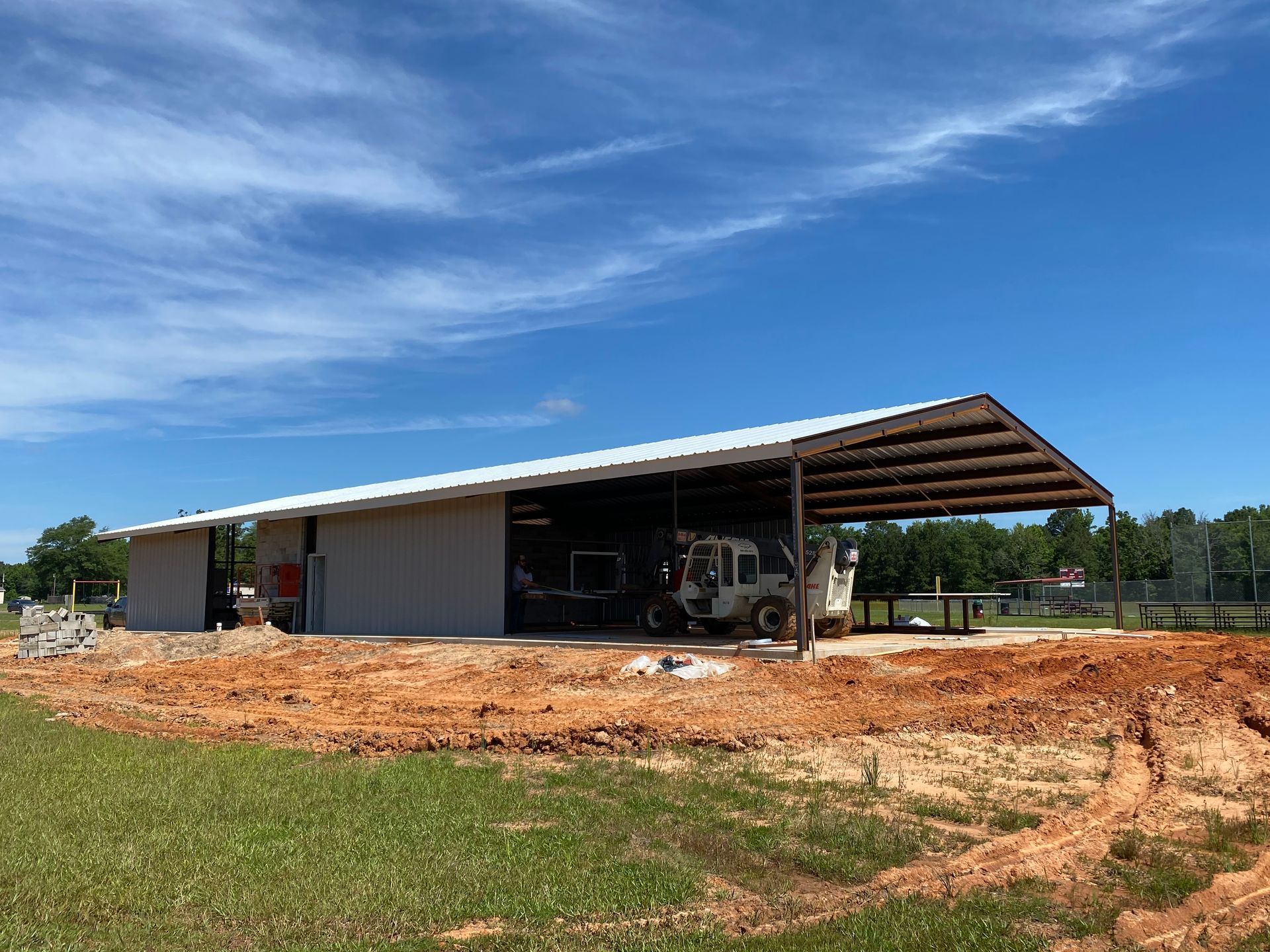 Gray metal building with a covered awning on a sunny day.