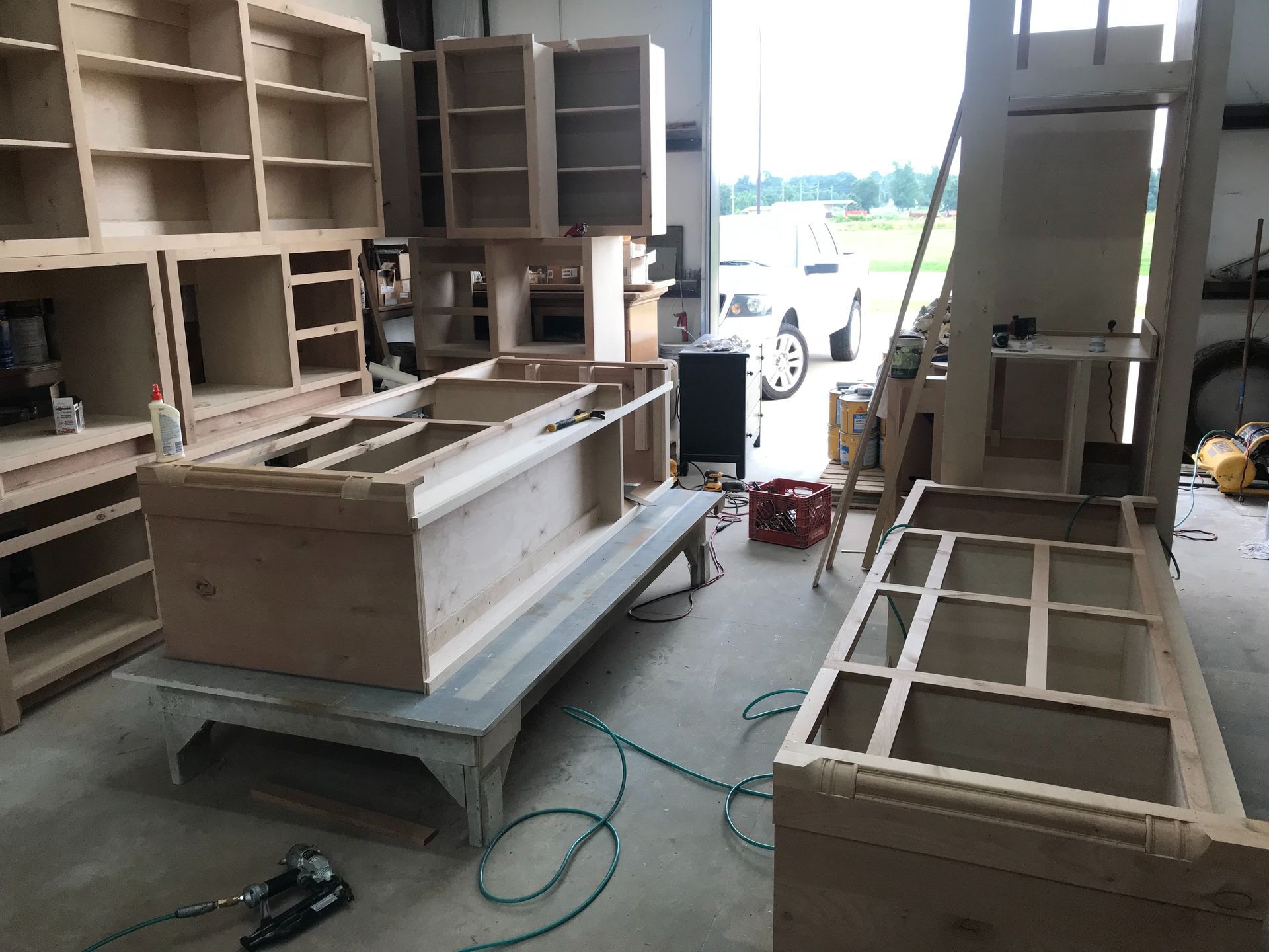 Wooden cabinet frames in a workshop; assembled and in progress.