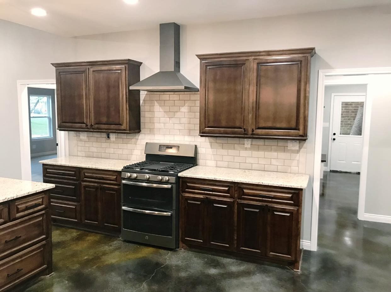 Kitchen with dark brown cabinets, light countertops, and a stainless steel range and hood.