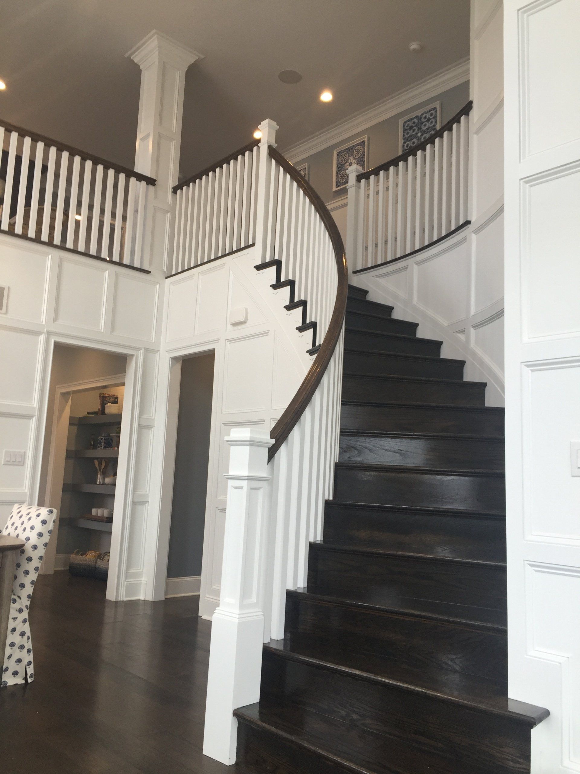 A staircase with a white railing and dark steps