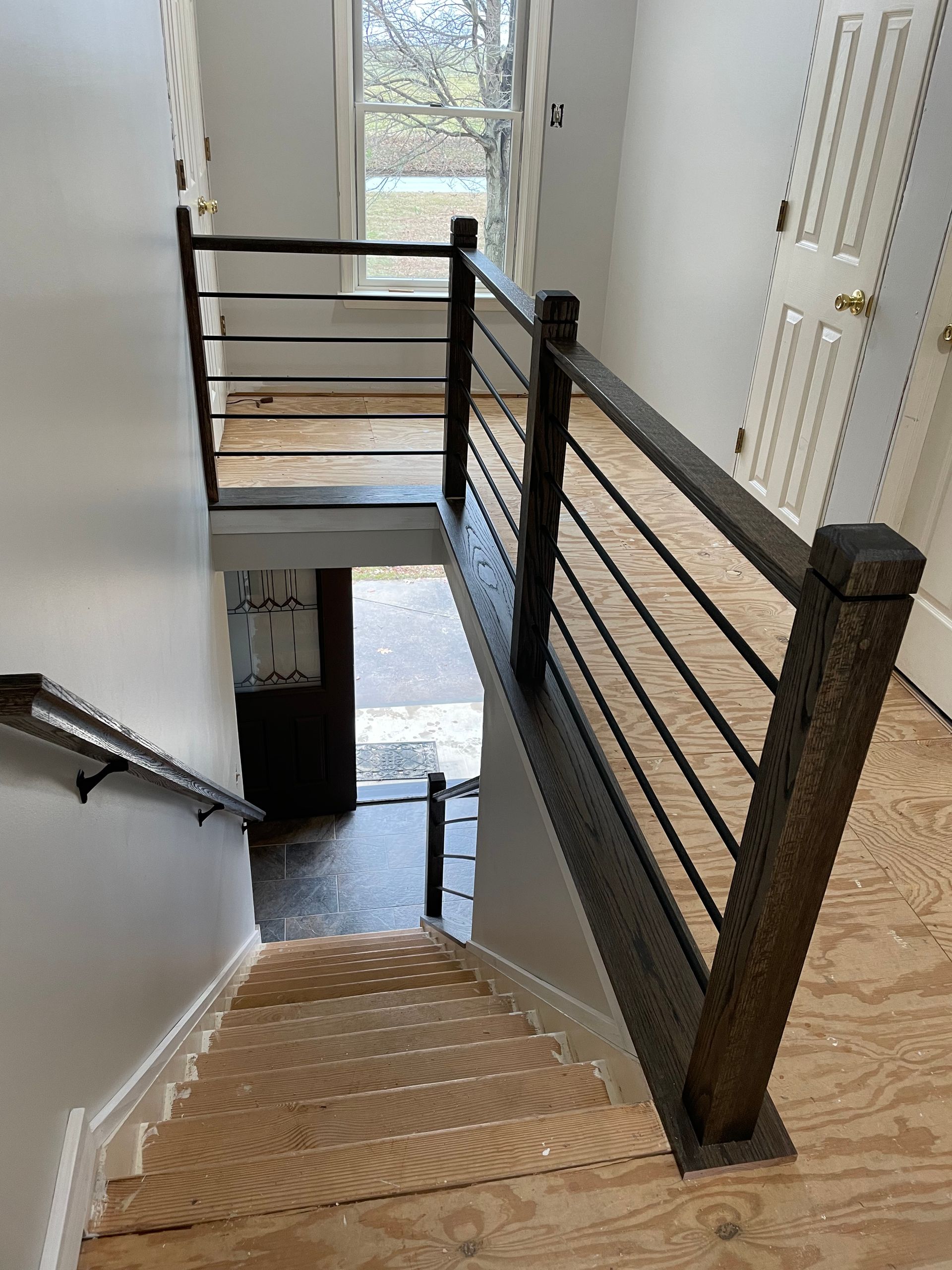 A wooden staircase with a metal railing in a house.