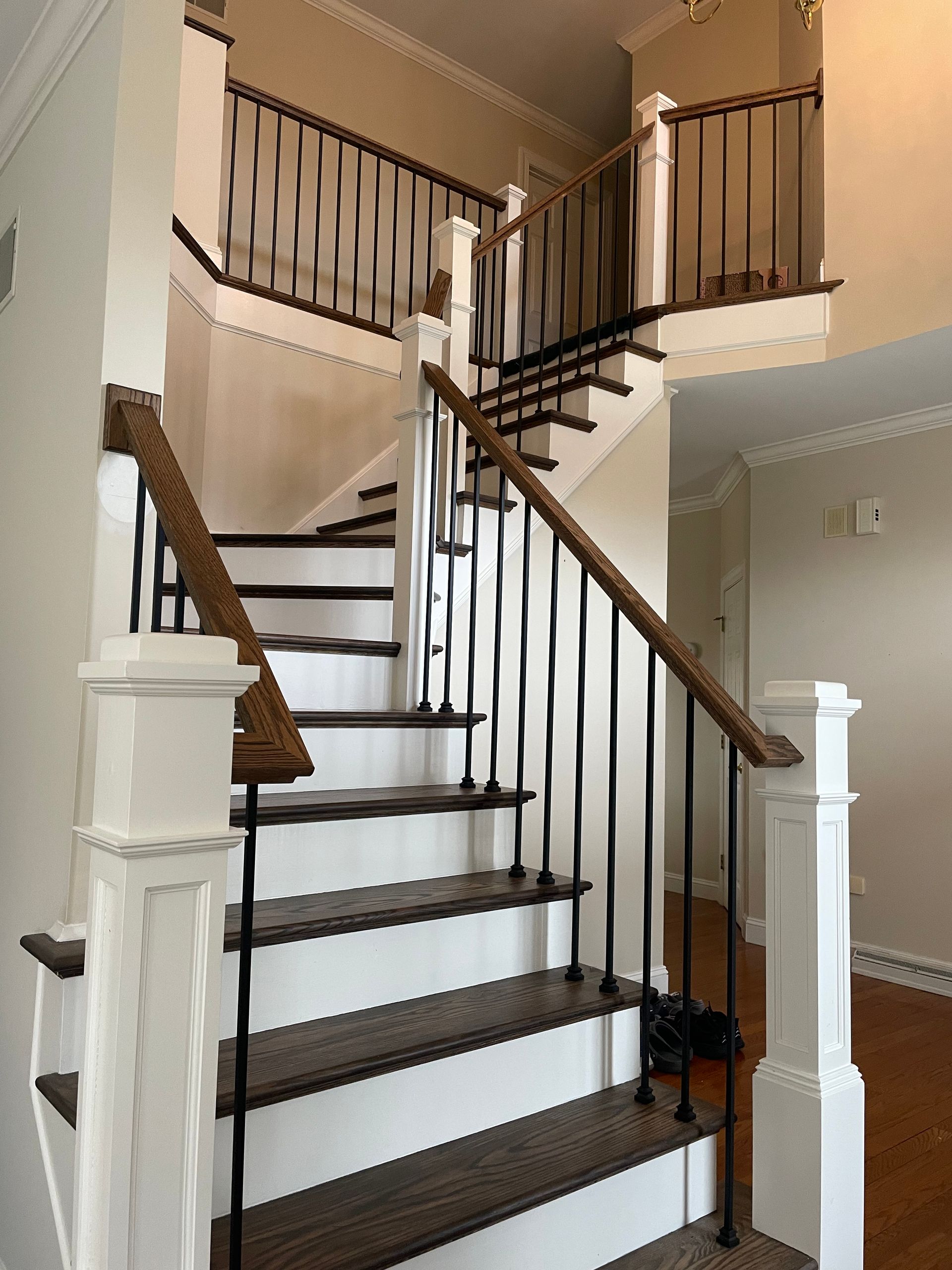 A staircase in a house with a white railing and wooden steps.