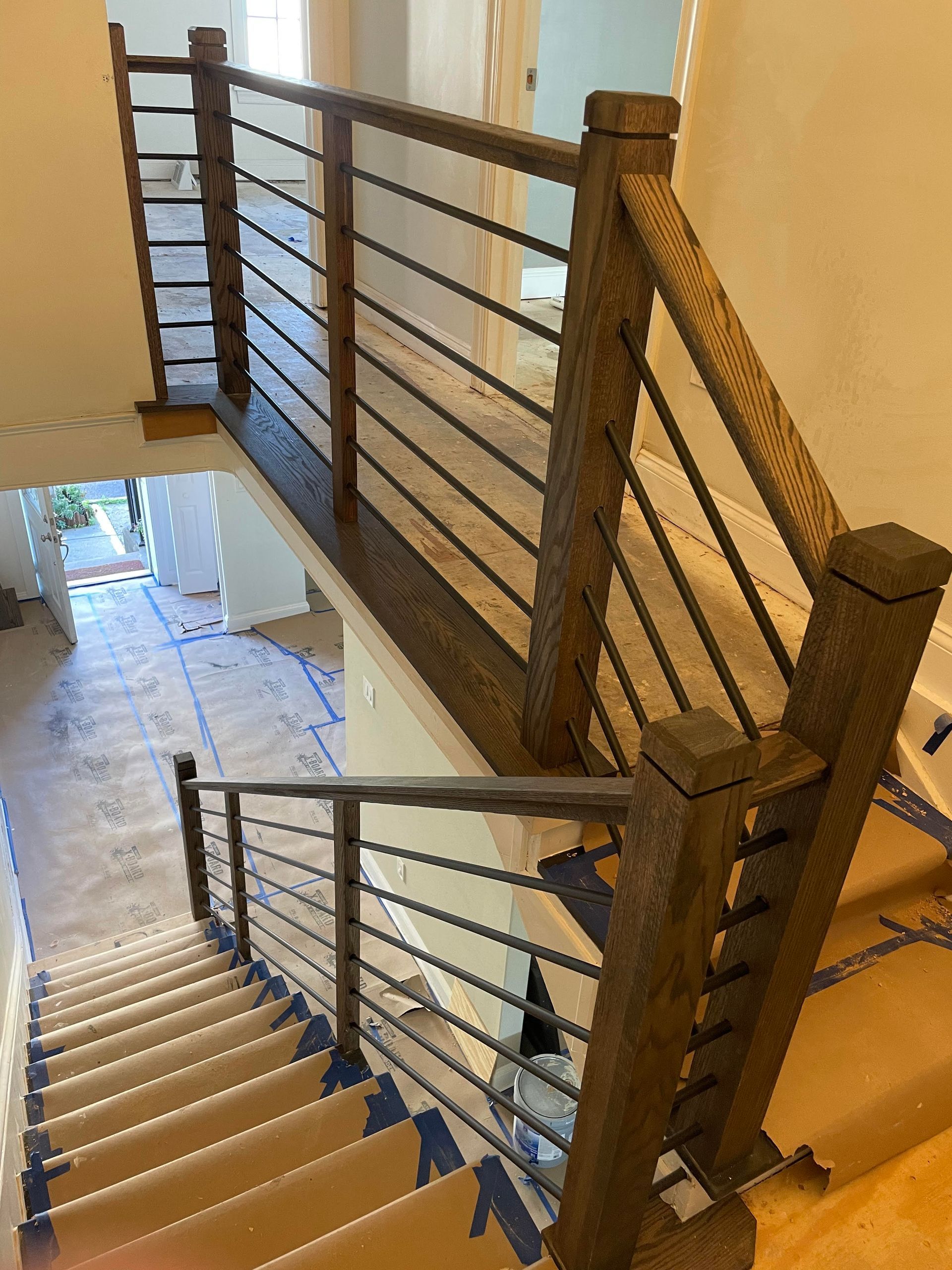 A wooden staircase with a metal railing in a house